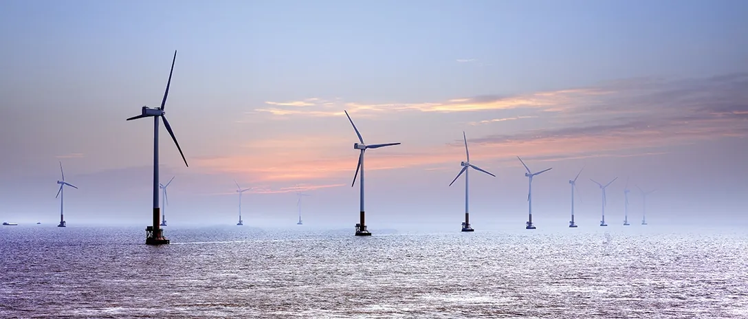 Wind turbines against a bright sky